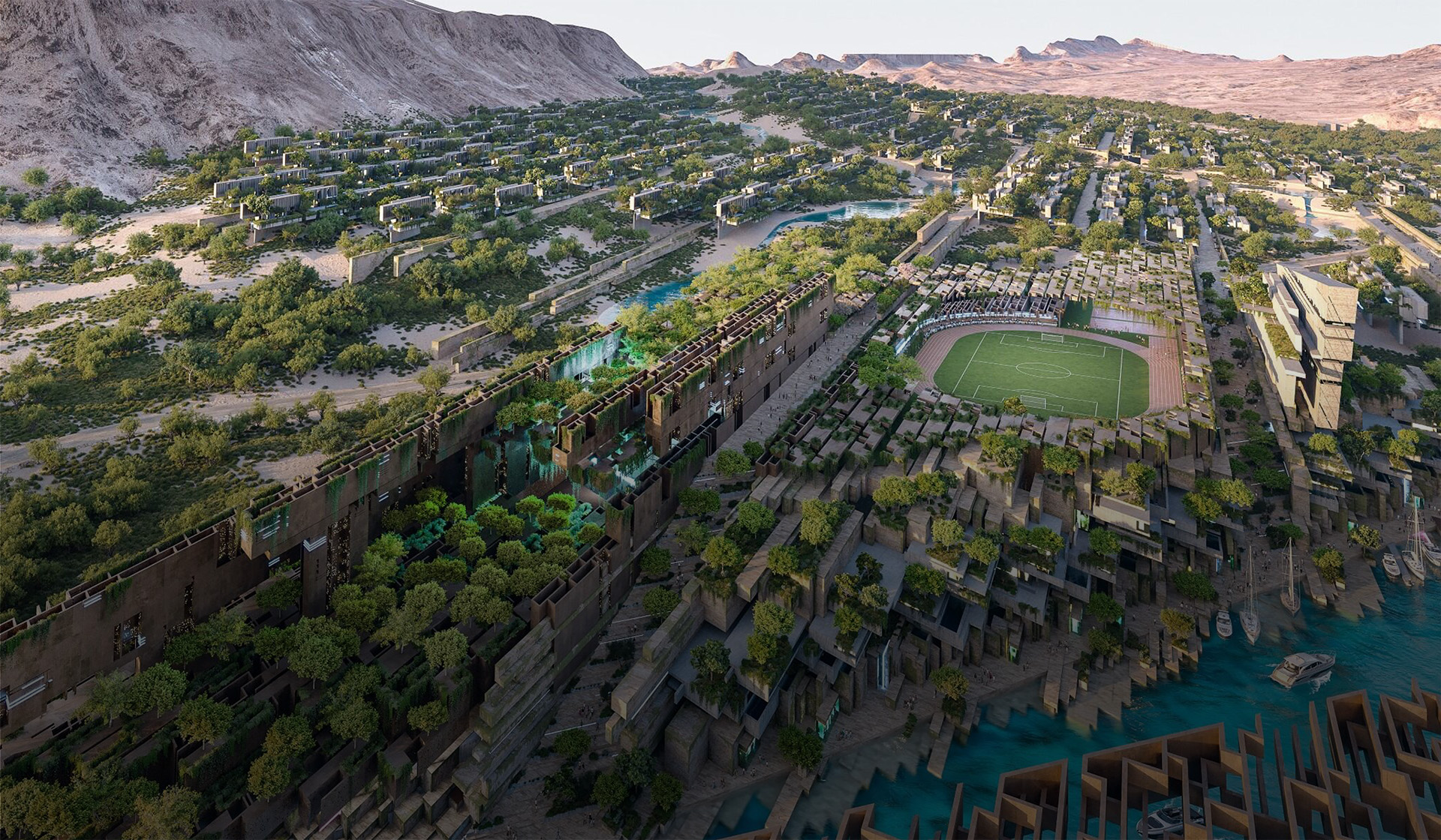 Aerial view of Jaumur's community nestled in mountains, with a large soccer stadium in the center